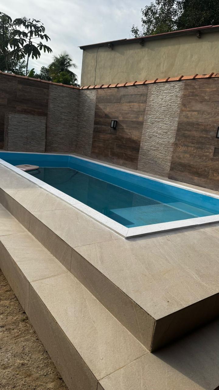 Piscina com piso atérmico bege e degraus revestidos em área externa