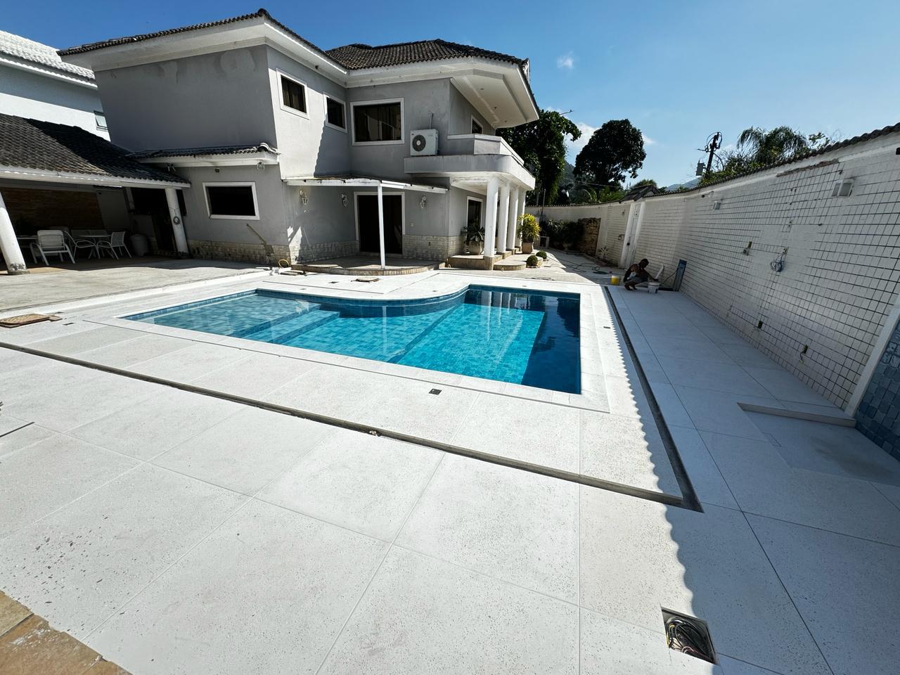 Ampla área de piscina com piso atérmico Bello ao redor de residência