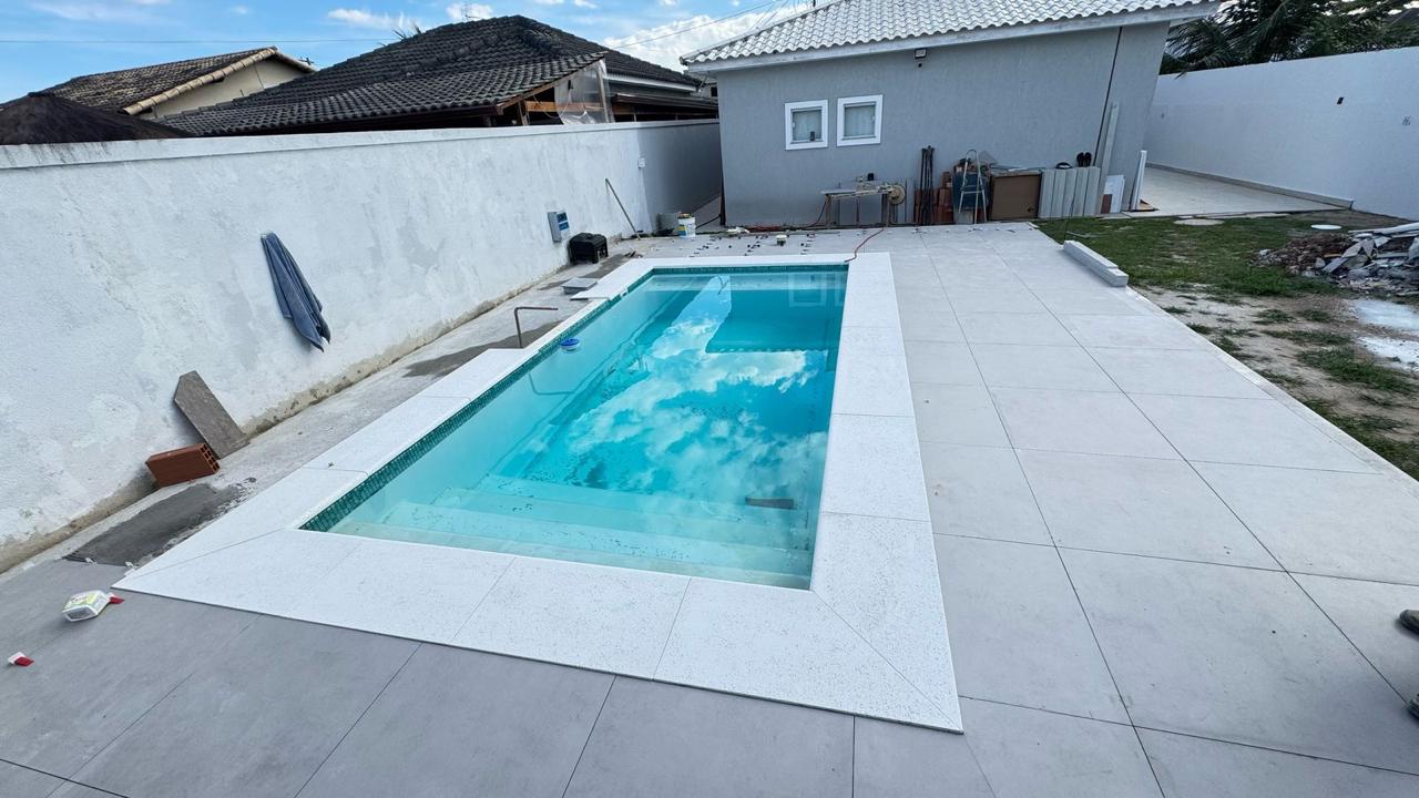 Piscina retangular com borda atérmica reta branca em obra residencial